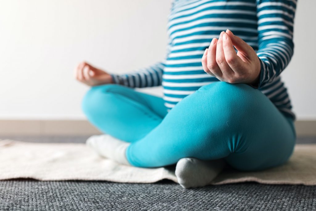 Pregnant woman practicing yoga exercise at home.