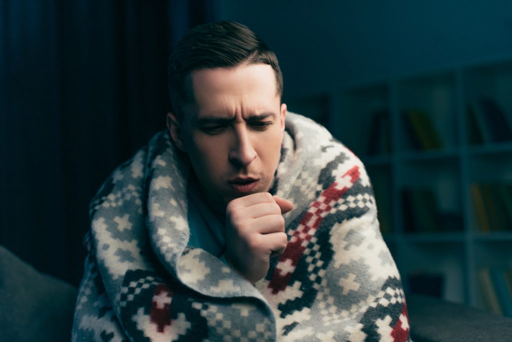 handsome man coughing while having flu at home. Coup de froid
