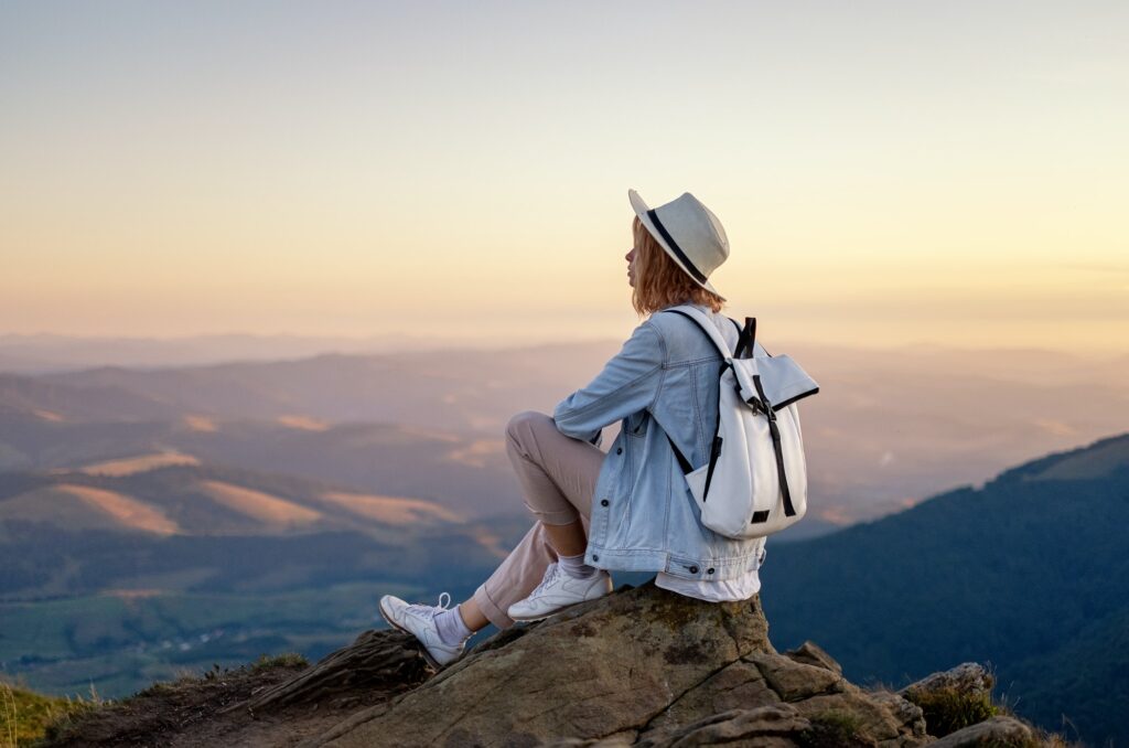 A girl with a backpack in the mountains. Tourism and adventure
