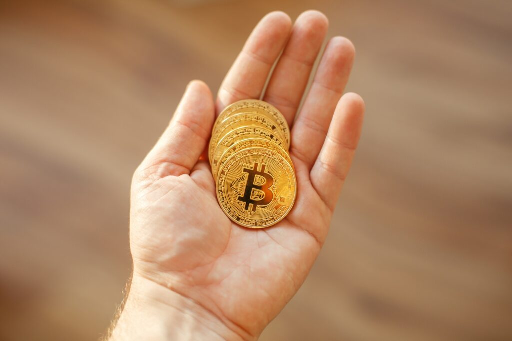 hand holding shiny golden bitcoins, gold money