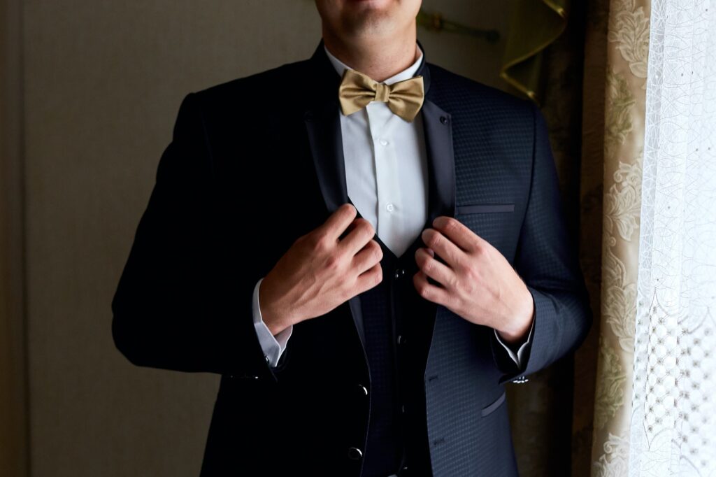 Handsome elegant young fashion man in coat tuxedo classical costume suit